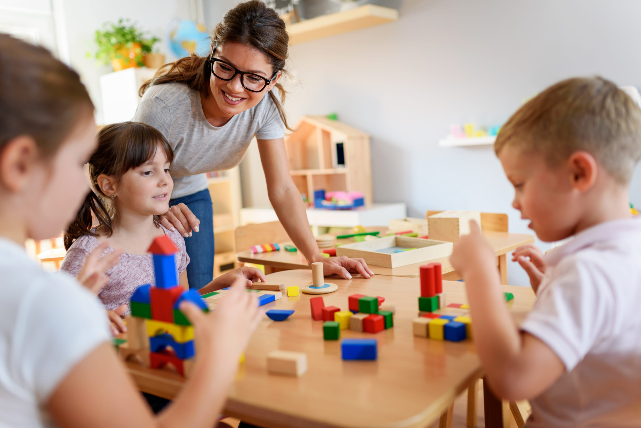 Preschool,Teacher,With,Children,Playing,With,Colorful,Wooden,Didactic,Toys